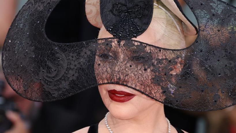 Lady Gaga in an elaborate black lace headdress and deep red lipstick