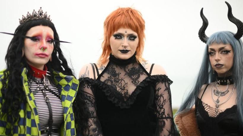 Three people wearing goth clothing