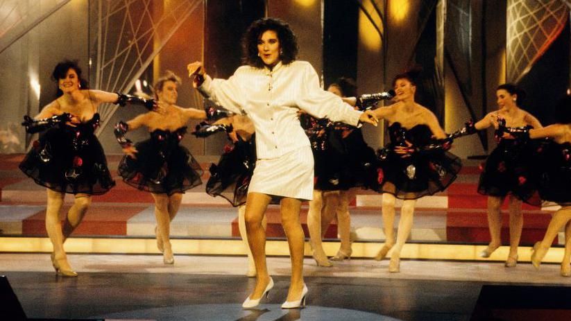 Celine Dion on stage in front of dancers at the 1988 Eurovision Song Contest