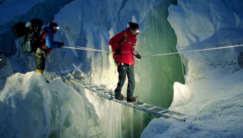 Lhakpa Sherpa on a ladder over a steep mountain drop