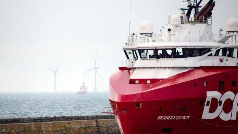 A supply ship in Aberdeen with turbines in the background at sea