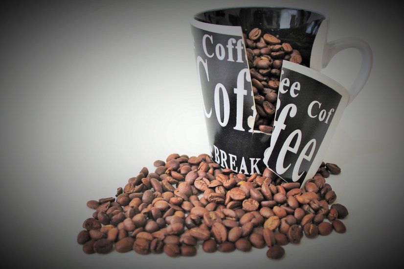 Broken mug with coffee beans