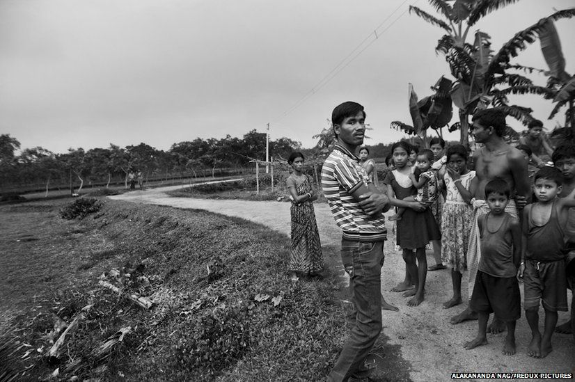 Indian citizens stand on Indian territory, right of frame. They stay away from stepping on to Bangladesh territory, left of frame.