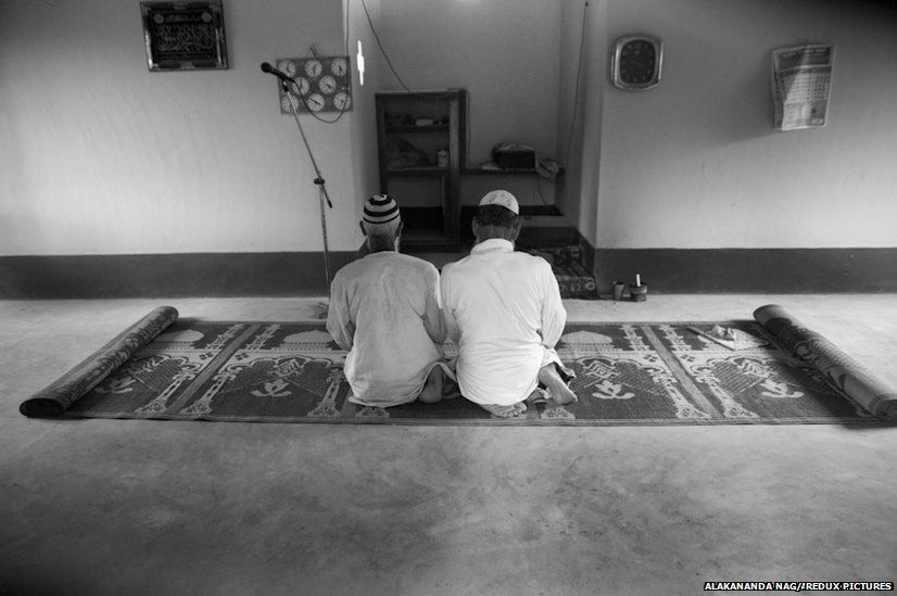 Men sit for evening prayers at the village mosque.