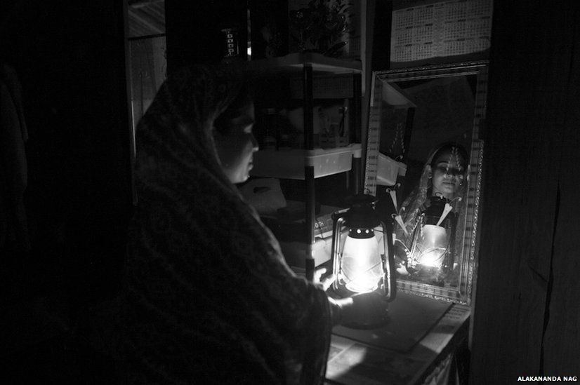 A woman lights a lantern