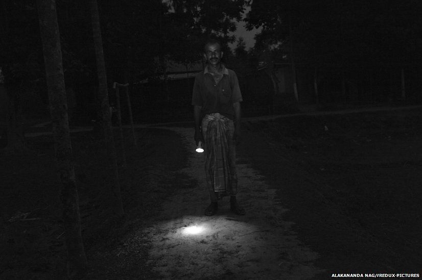 Mohammad Shahjamal Sheikh stands with a torch in his hand