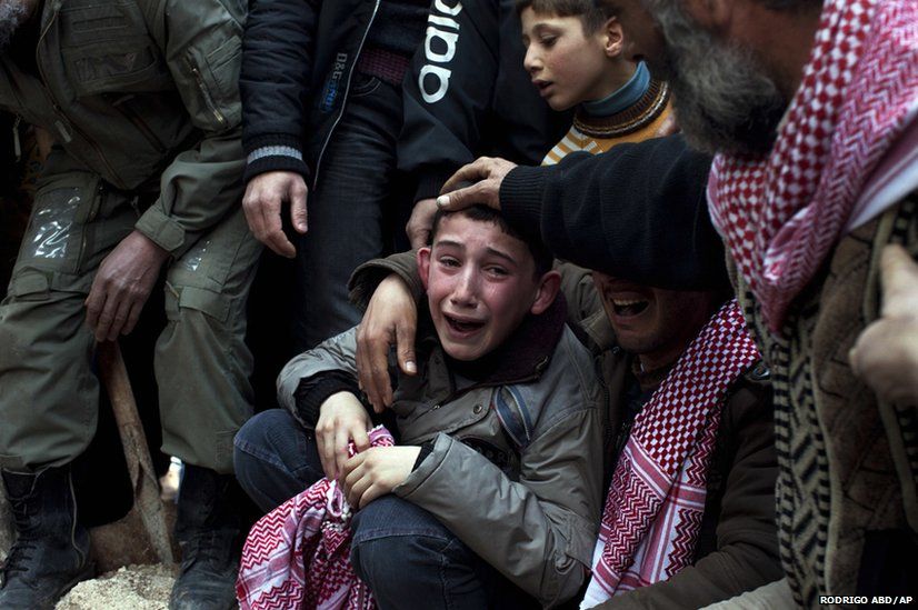 A boy named Ahmed mourns his father, Abdulaziz Abu Ahmed Khrer, who was killed by a Syrian army sniper, during his funeral in Idlib, northern Syria, 8 March, 2012