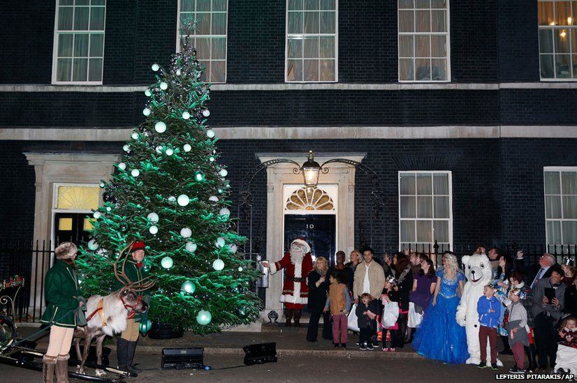 Guests gather for the lighting of a Christmas tree outside the official residence of Britain's Prime Minister David Cameron
