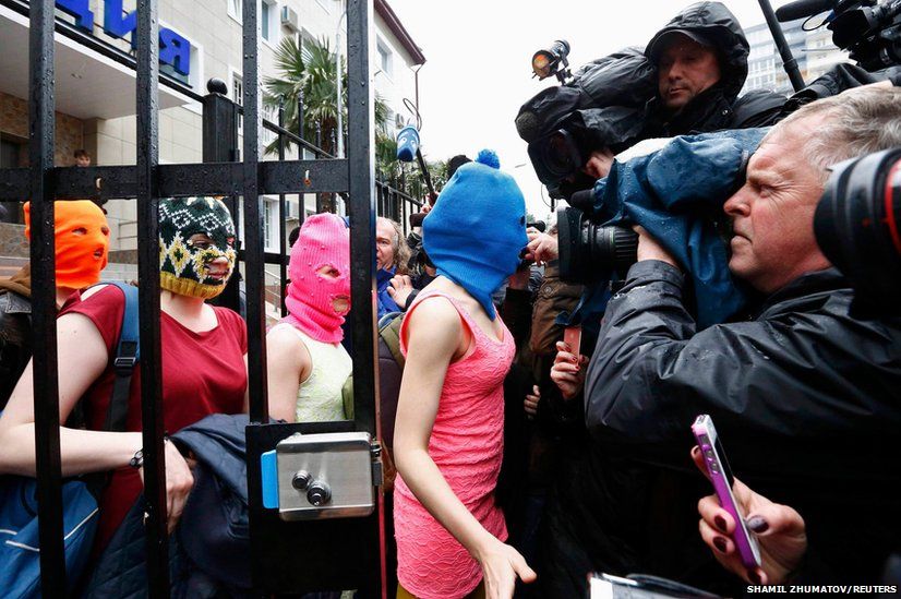 Masked members of Pussy Riot leave a police station in Adler with two other masked women