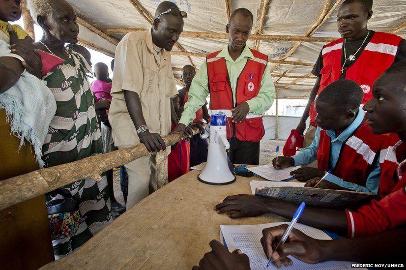Matiop (wearing wristwatch) registers his family with Uganda Red Cross volunteers.