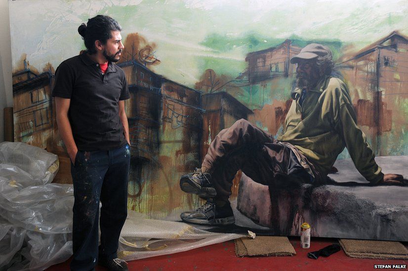 The artist and muralist Alfredo Gutierrez with his portrait of an American homeless man in Tijuana, Baja California, Mexico