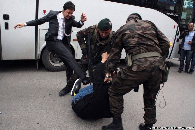 A protester is kicked by Yusuf Yerkel (left), advisor to Turkey's Prime Minister Tayyip Erdogan