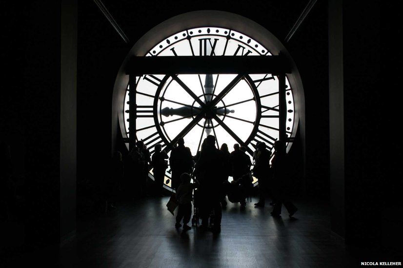 Figures in front of a clock face