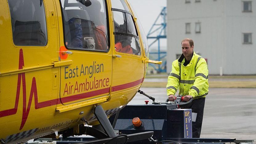 Archive image of Britain's Prince William, The Duke of Cambridge (C) manoeuvres an air ambulance as he begins his new job with the East Anglian Air Ambulance