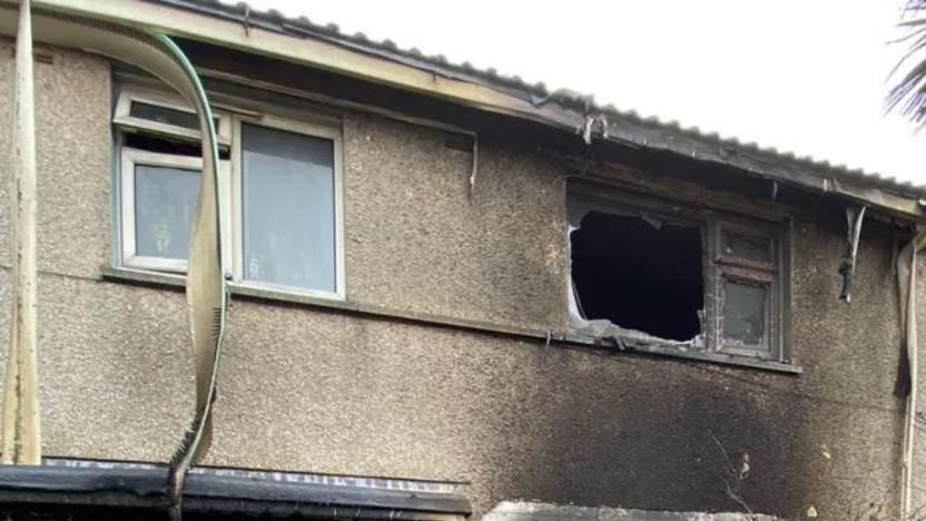 A blown upper floor window after a fire at a house 