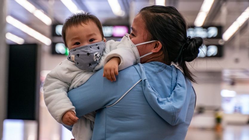 Una madre y un niño pequeño usando mascarillas en China.