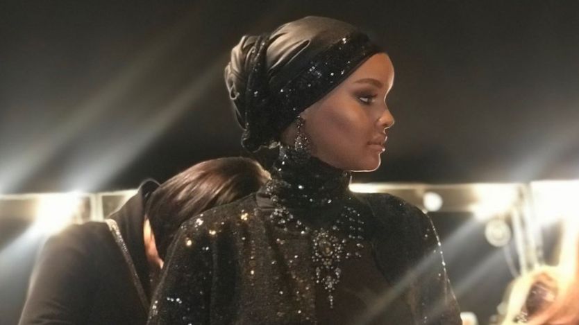 Halima Aden memakai hijab hitam.