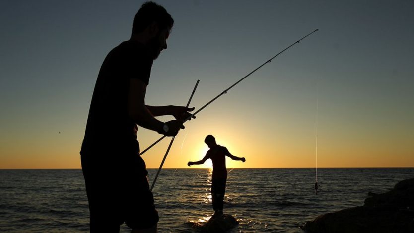 Libyans fish from the shore in the eastern city of Benghazi on June 14, 2017