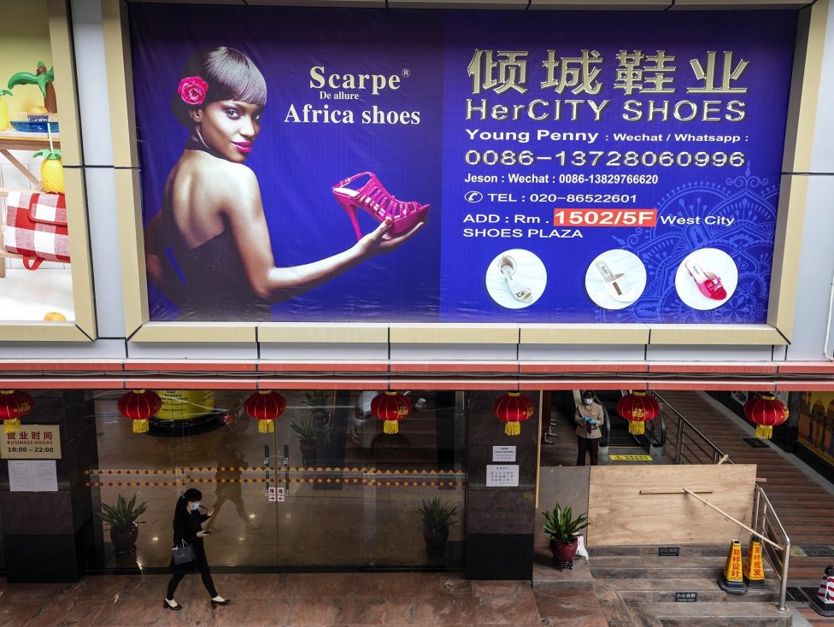 Une femme passe devant un panneau d'affichage dans une partie de la ville où la plupart des Africains vivent et travaillent à Guangzhou, dans la province du Guangdong, en Chine, le 13 avril 2020.