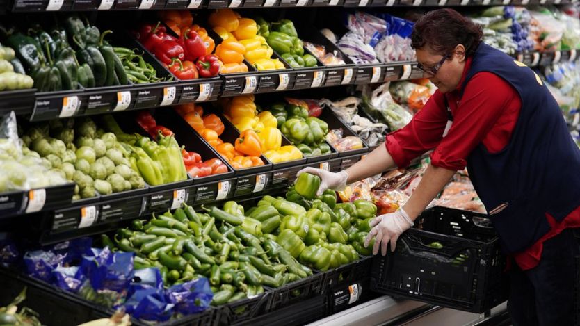 Walmart employee stacks vegetables