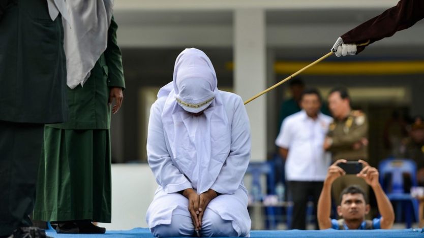 A woman is whipped in public by a member of the Sharia police in Banda Aceh on October 31, 2019