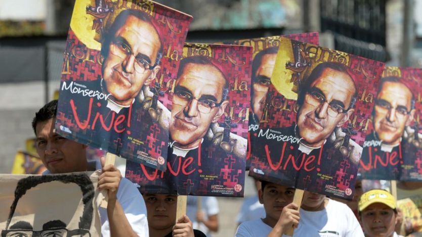 Fieis com cartazes do monsenhor Arnulfo Romero em que se lê "Monsenhor vive!"