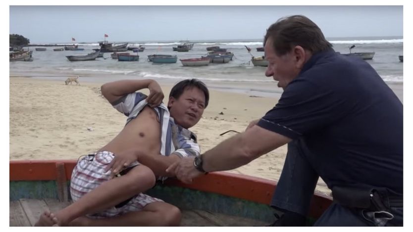 Ông Andre Menras trò truyện với một ngư dân từng bị tàu Trung Quốc bắn