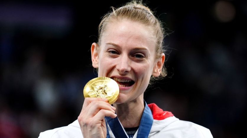 Bryony Page holding a gold medal to her mouth