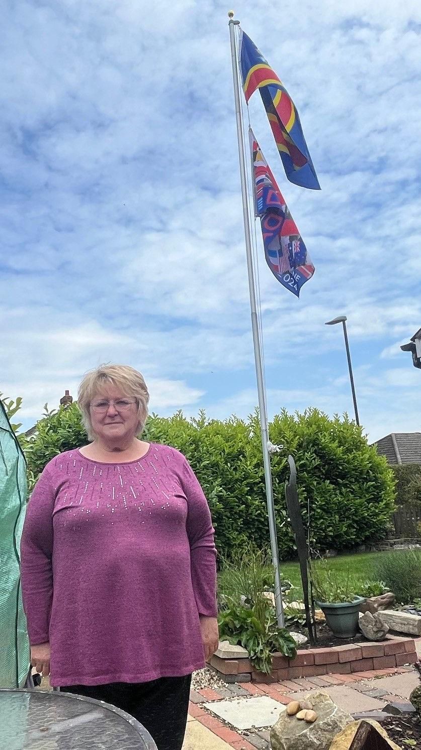 Julie Ward next to her flagpole 