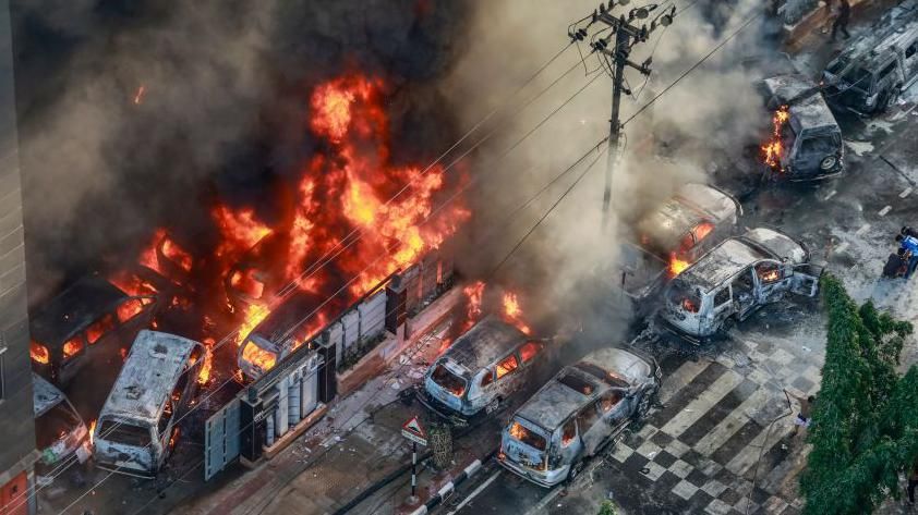 Smoke rises from the burning vehicles after protesters set them on fire near the Disaster Management Directorate office, during the ongoing anti-quota protest in Dhaka on July 18, 2024