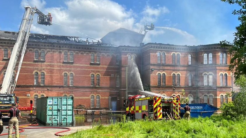 firefighters spraying water at fire in Broadmoor Hospital building