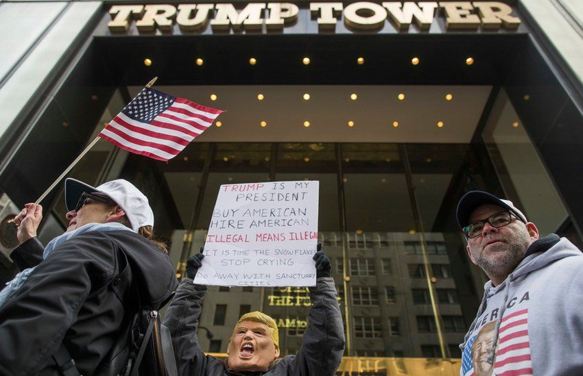 A protester holds up a sign outside Trump Tower