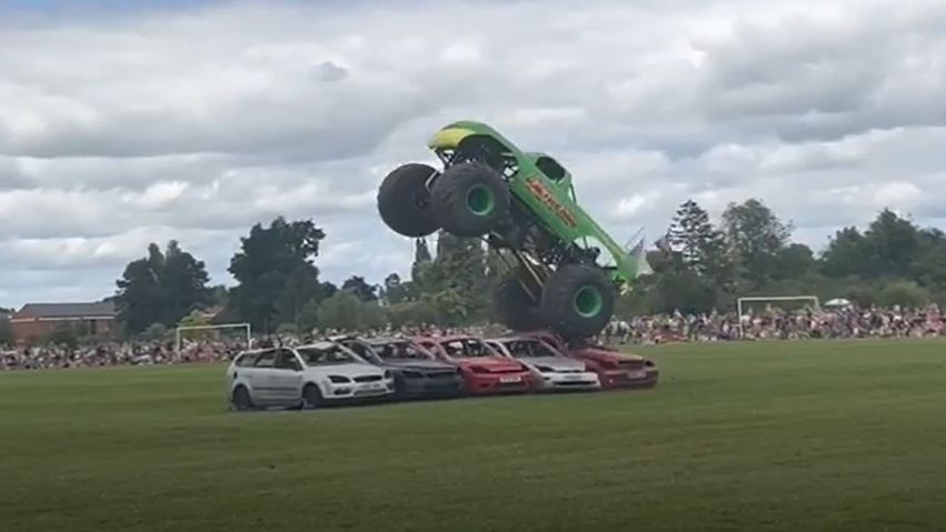 A monster truck driving over cars