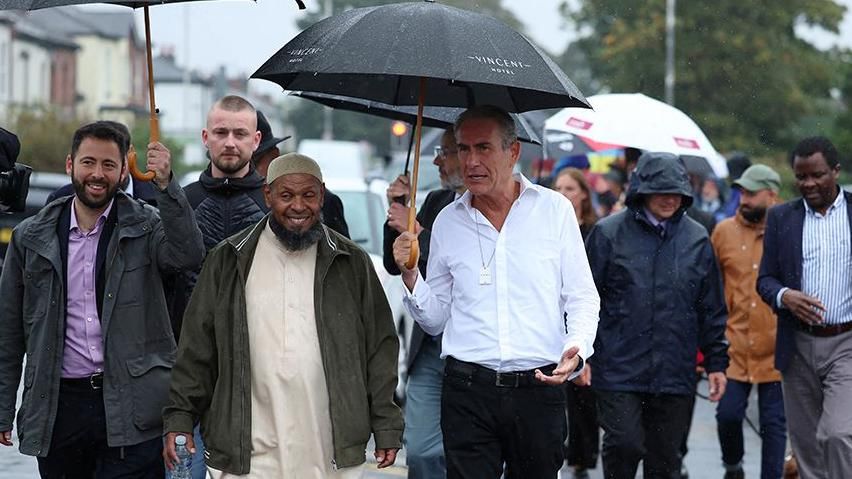 Local faith leaders taking part in the Walk of Unity in Southport with many holding umbrellas to protect themselves from the rain