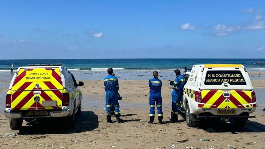 The Royal Navy and coastguard team members and vans on the beach