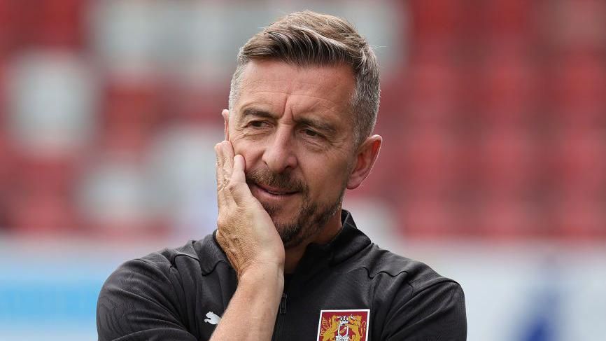 Northampton Town manager Jon Brady thinking on the touchline