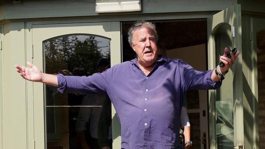 Jeremy Clarkson on the left outside the pub next to a blackboard sign