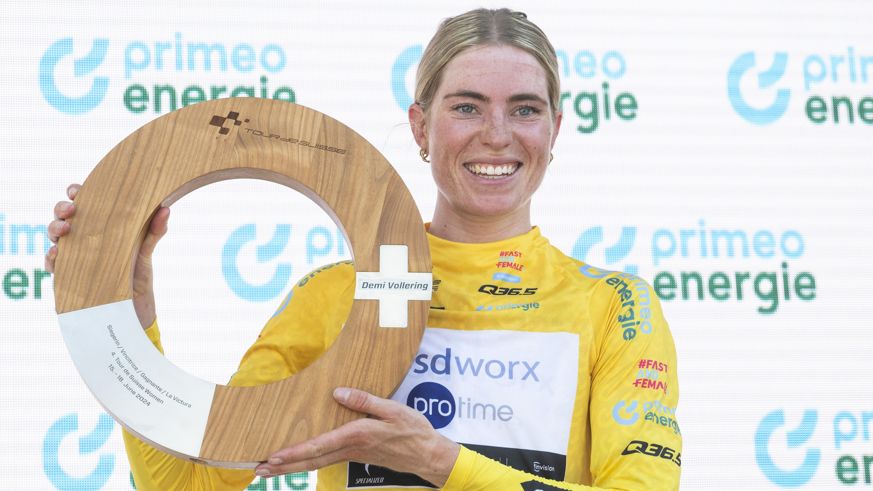 Demi Vollering smiles while holding the Tour du Suisse trophy after winning the 2024 event