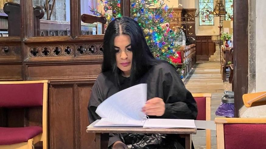 Laura Brown looks at a book of condolence in the church