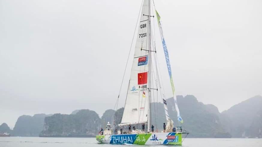 A large sailing yacht on the ocean. It has the name ZHUHAI on the side, with blue, green and white colours on the side