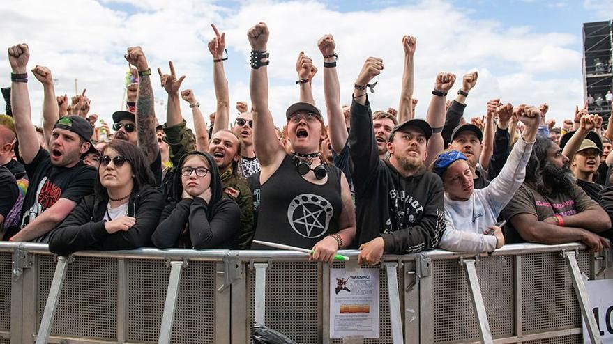 General view of festival goers raising their arms at the main stage at Download festival in 2022