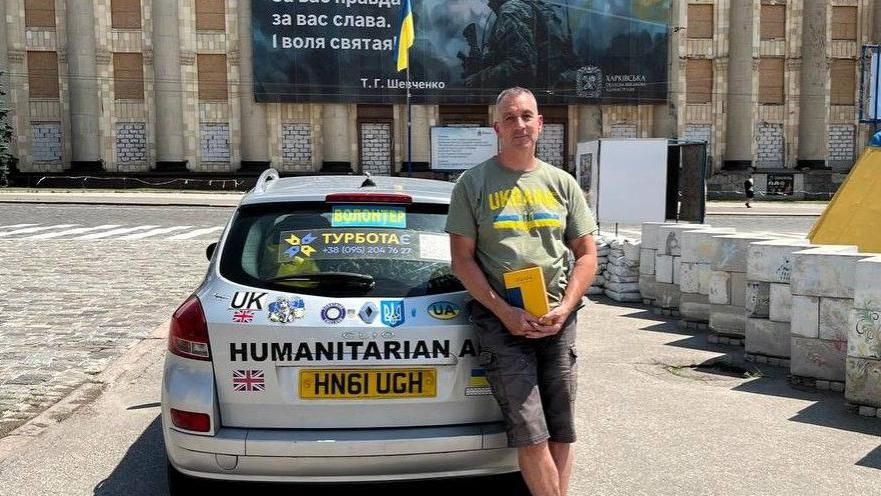 Michael Betoin standing with his aid vehicle