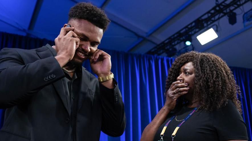 Travis Clayton taking a call after being selected at the 2024 NFL draft, as his mother watches on