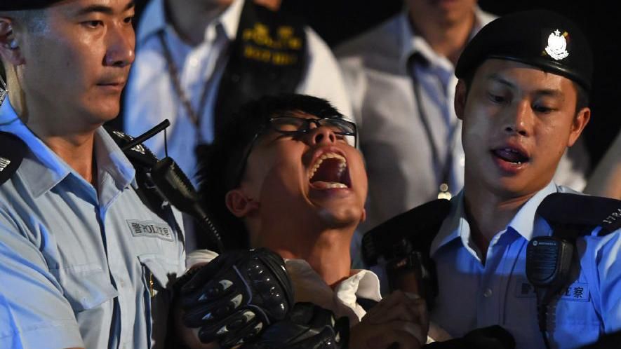 Johsua Wong screams as he is detained at a pro-democracy protest 
