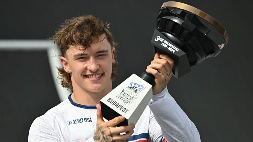 Kieran Reilly poses with his trophy after finishing third overall in the Cycling BMX Freestyle Men's Park Final of the Olympic Qualifier Series in Budapest in 2024