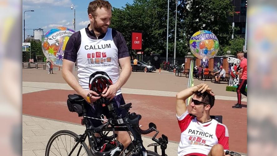 Two men pose with their bicycles after a race. One is in an adjusted bicycle for mobility issues