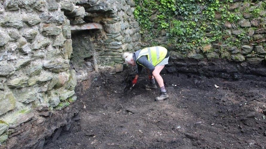 An archaeologist working at St Cybi's Churchyard, Holyhead