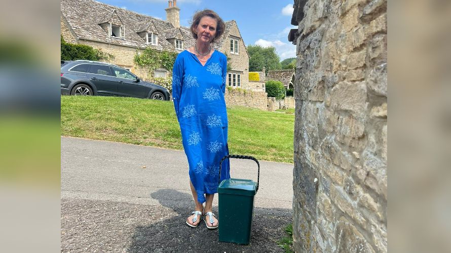 Julia Judd stood next to a food bin in a Cotswolds village