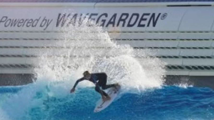 A surfer rides an artificial wave on his board 