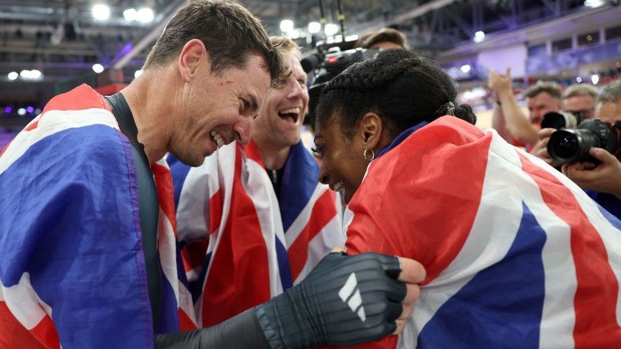 Kadeena Cox with Jaco van Gass and Neil Cundy holding a union jack flag after winning gold in the velodrome